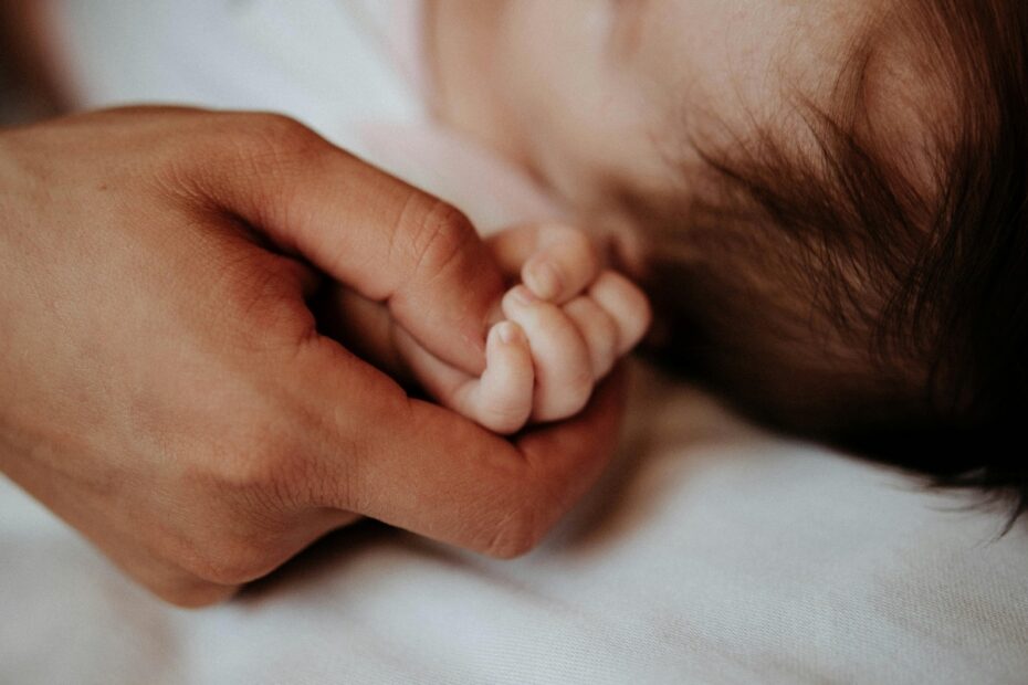 Close-up of the Father Holding His Newborn Baby Hand