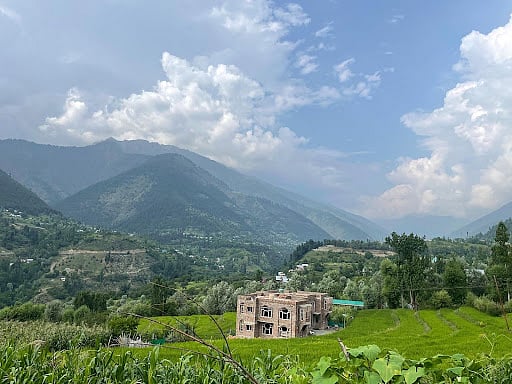 A large house is being built on terraced land that was once used for farming, showing how no piece of land is safe from development.