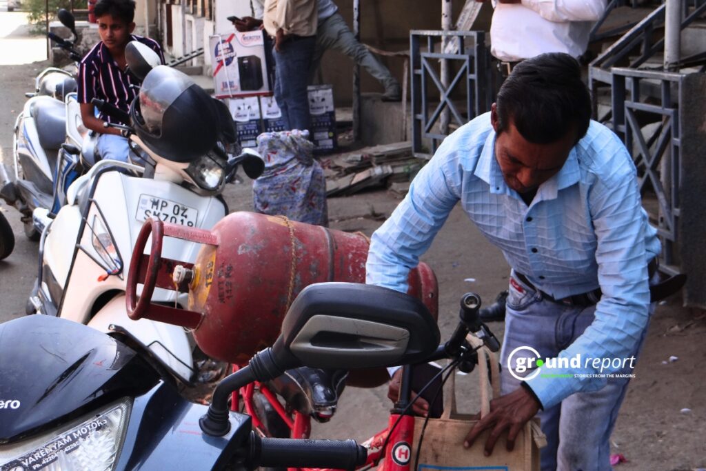 A consumer taking a gas cylinder home tied to a bicycle — Bhopal, Madhya Pradesh.