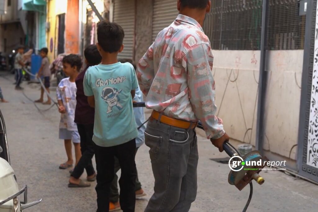 Children helping to retrieve a submersible motor from a dried-up borewell.