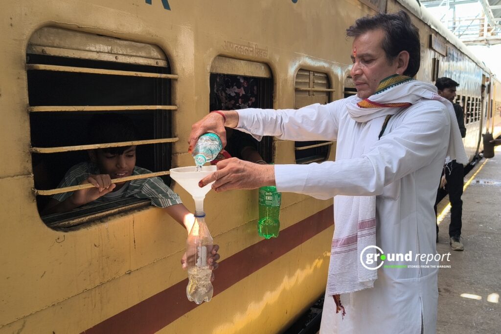 ट्रेन की खिड़कियों से अपनी पानी को बोतल भरवाते रेलयात्री
