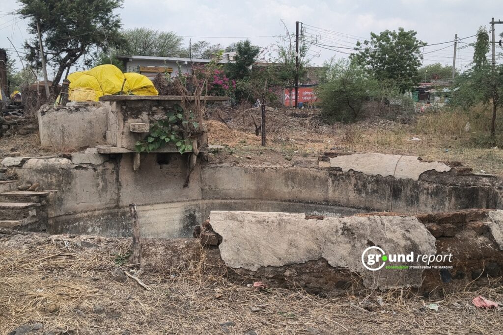An old, broken-down water structure, now abandoned and overgrown with weeds.