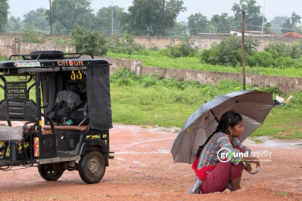 मध्य प्रदेश के ओरछा में बारिश से बचने के लिए छाता लेकर बैठी महिला | फोटो: पल्लव जैन