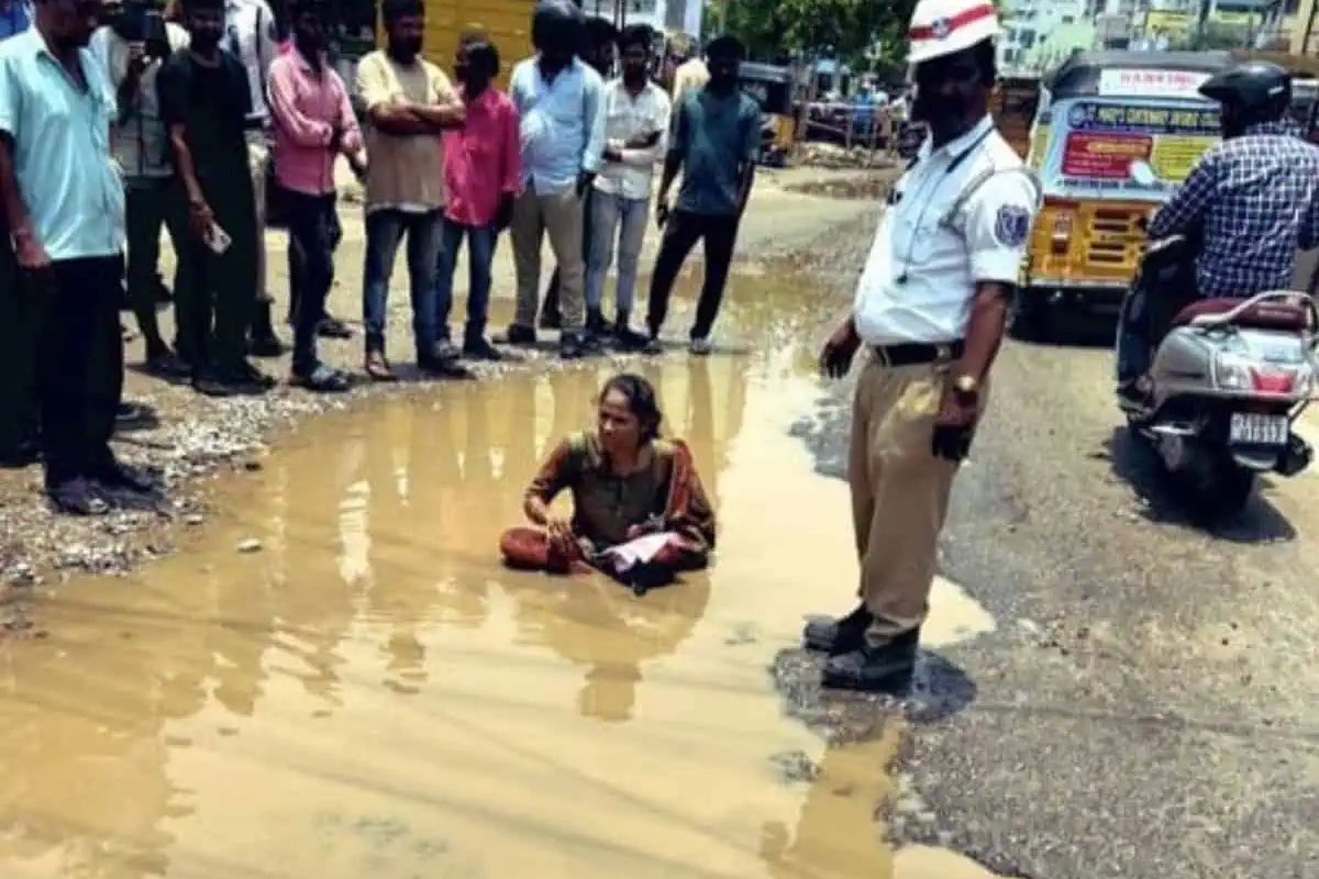 Woman sits in water-filled pothole to protest Hyderabad's bad roads