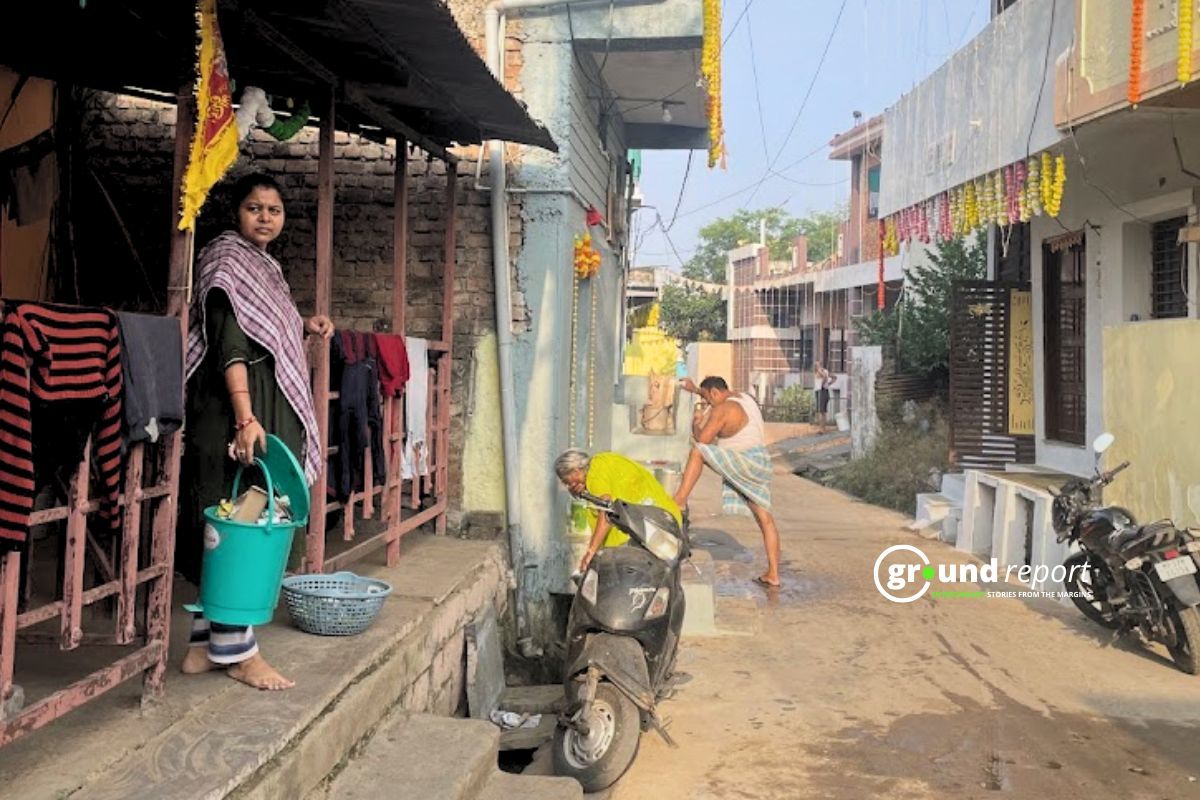 A woman waits for a garbage pickup vehicle in the Kasba area of Sehore