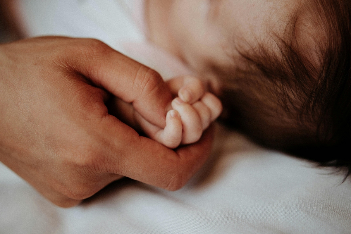 Close-up of the Father Holding His Newborn Baby Hand