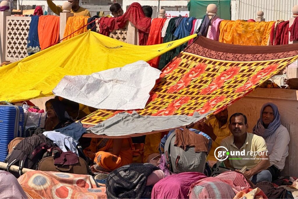 Devotees sit under the cover of cloth to avoid the sun in the Kubereshwar Dham premises.