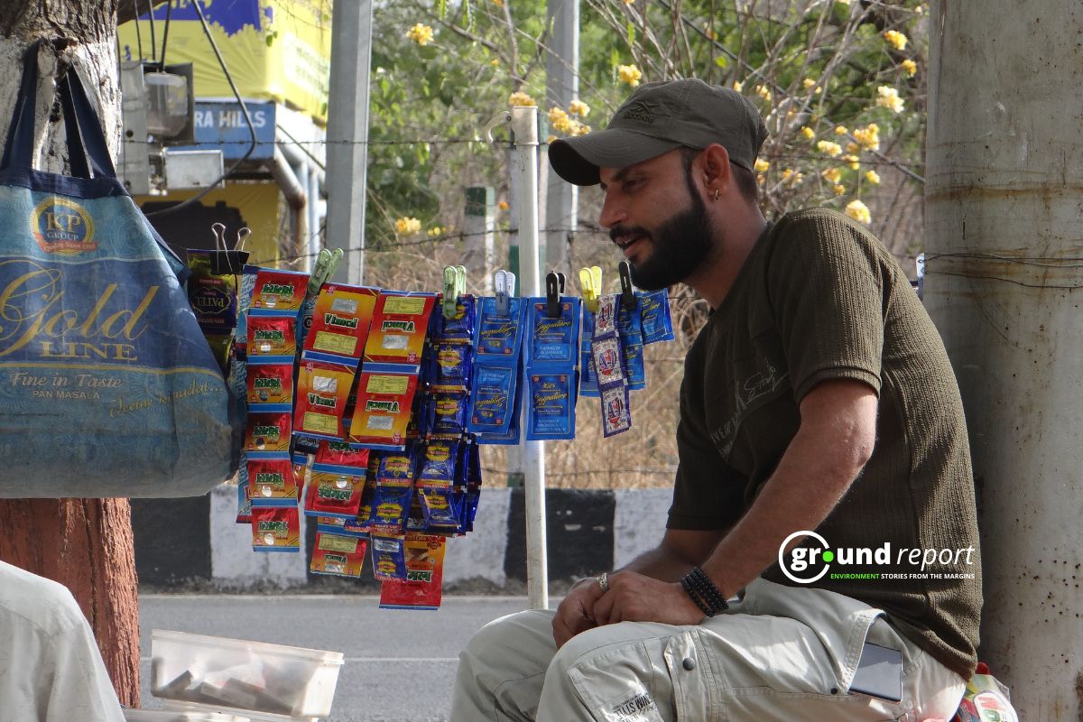 A vendor sits beside rows of gutkha and pan masala pouches at a street stall. Enforcement of India's gutkha ban remains weak across most states.