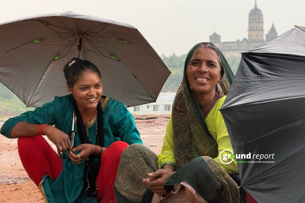 ओरछा, मध्य प्रदेश में बारिश में छाता लेकर बैठी महिलाएं । फोटो: पल्लव जैन
